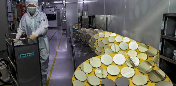 Funcionário manuseia semicondutores em fábrica na China