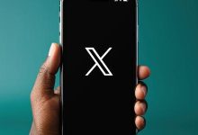 Pessoa segurando um iPhone X com o logo da rede social X