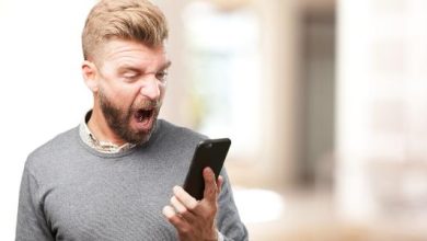 Homem com celular smartphone e expressão de raiva ódio nervoso