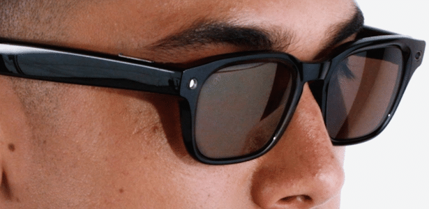 Homem usando óculos inteligentes Meta Glass; repare que no lado direito dos óculos há uma luz acesa; ela indica que a câmera está funcionando