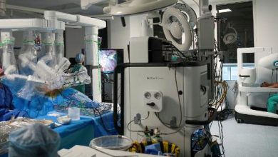 Esta foto, tirada em 3 de julho de 2026, mostra o cirurgião Sasha Stamenkovic (à extrema direita) -- diretor de cirurgia robótica, pesquisa e programas de especialização -- realizando uma cirurgia de câncer de pulmão com o novo sistema cirúrgico assistido por robô Da Vinci 5, com o auxílio de enfermeiros (à esquerda), no Hospital St. Bartholomew, em Londres